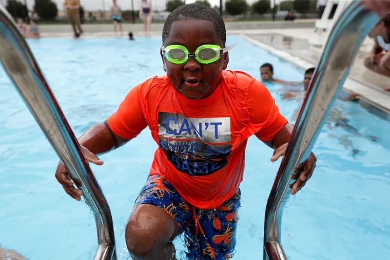 Kaden Colston, 8, who is in the Bridesburg summer camp, climbs out of the pool after swimming during the 2019 Public Pools Season Opener and Grand Opening of Bridesburg Pool in Philadelphia on Monday.