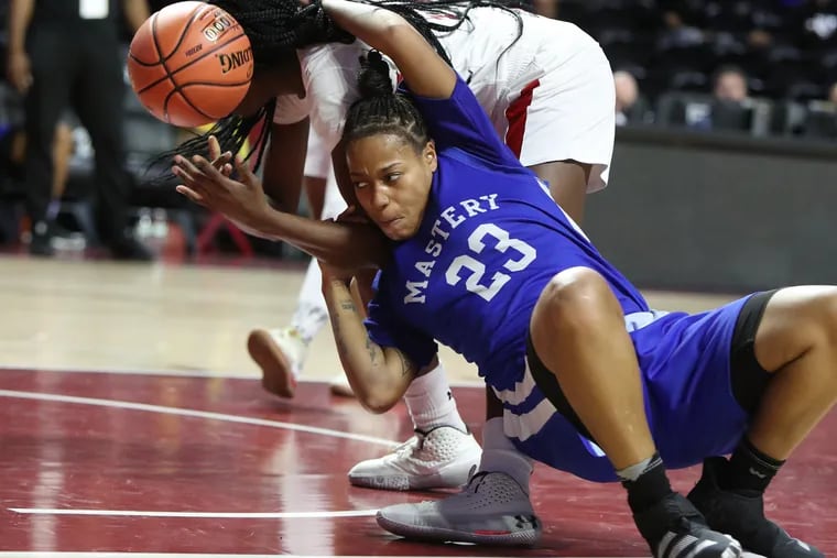 Janai Smith, left, of Imhotep Charter and Angela Sanders of Mastery Charter North get wisted up as they battle for the ball during the Philadelphia Public League Championship for girls at the Liacouras Center on Feb. 22, 2020.