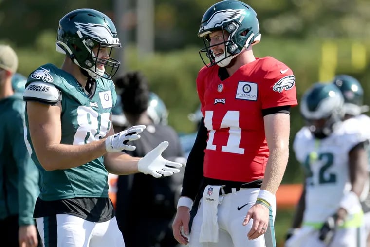 Carson Wentz talks things over with tight end Dallas Goedert during Wednesday's practice at the NovaCare Complex.