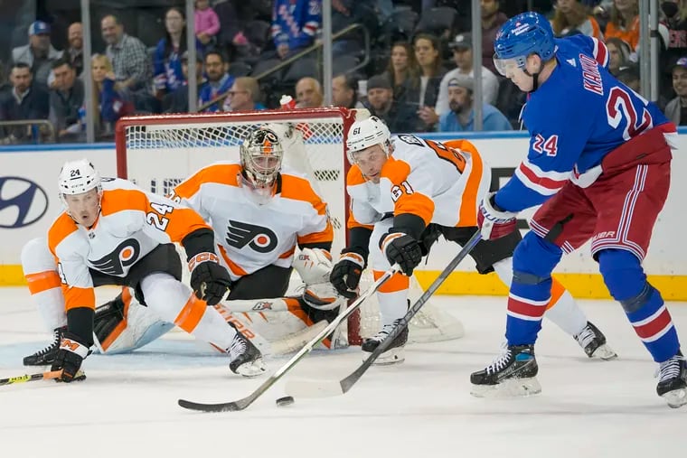 Carter Hart (center) and the Flyers played to a scoreless draw in regulation before the New York Rangers scored the game-winner Tuesday night in New York.
