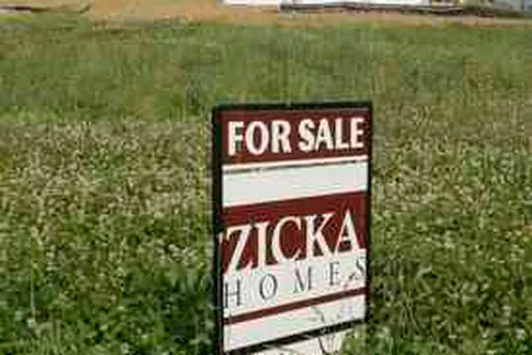 A for-sale sign is posted in a lot next to a home under construction in Cincinnati. Sales of new homes hit a record low in May.