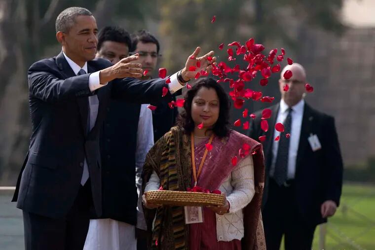CAROLYN KASTER / ASSOCIATED PRESS President Obama throws rose petals in a wreath-laying ceremony yesterday at the memorial to Indian independence leader Mahatma Gandhi in New Delhi.