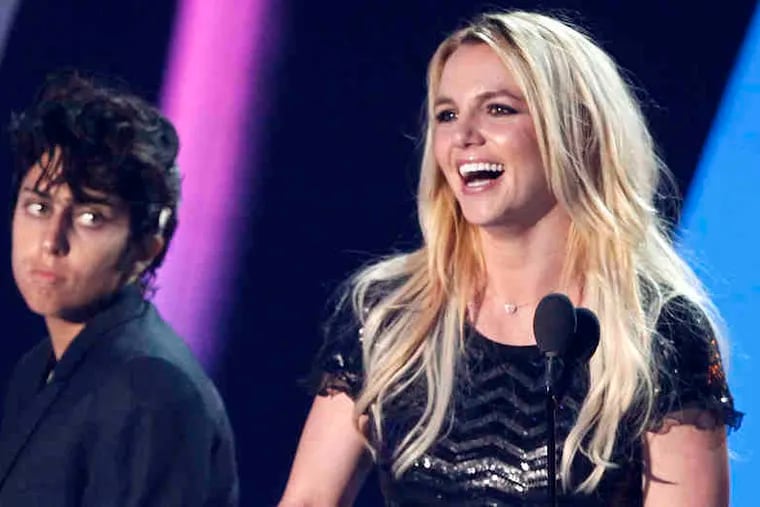 Britney Spears accepts her Video Vanguard award as Lady Gaga, in her Jo Calderone guise, looks on.