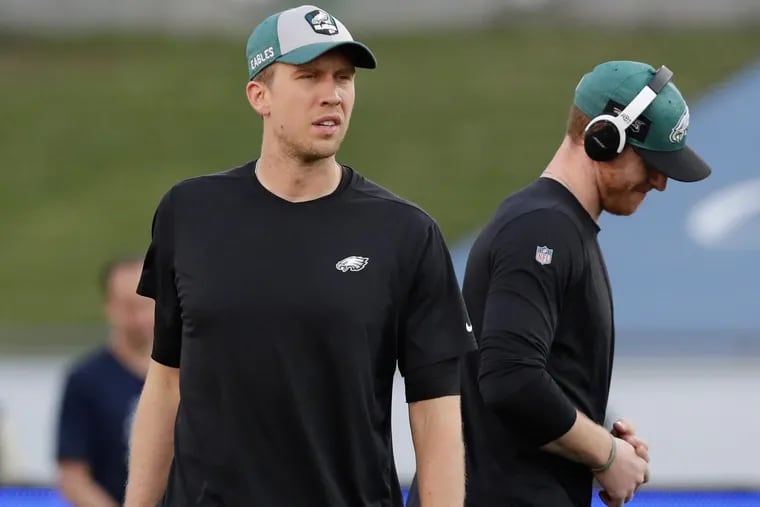 Eagles quarterbacks Nick Foles (left) and Carson Wentz were on the field together during warm-ups Sunday before the team's 30-23 victory over the Rams.