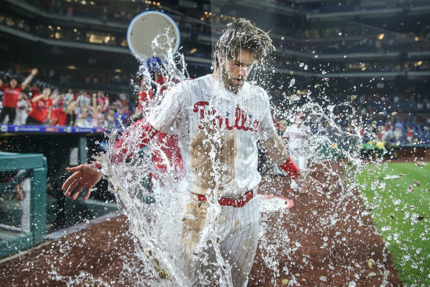 Phillies' Bryce Harper gets a water bath from teammate Jean Segura after his walk-off two run double against the Dodgers to win the game 9-8 at Citizens Bank Park in Philadelphia, Tuesday, July 16, 2019