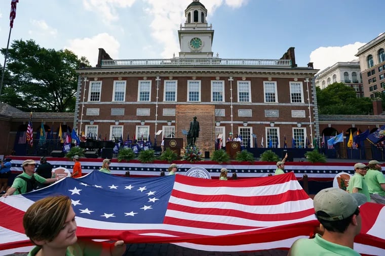 A Flag is carried past Independence Hall, where the U.S. Constitution and Declaration of Independence were debated and signed, on the 4th of July, 2019. Inspired by the anniversary of enslaved Africans first reaching the U.S, historians are reconsidering the earliest stories of American history.