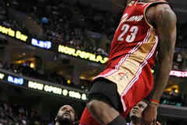Cavaliers' LeBron James goes up for a dunk in third quarter as teammate Shaquille O'Neal looks on.