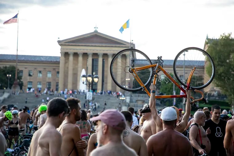 A man holds up his bike at The Oval at the end destination for the Philadelphia Naked Bike Ride on August 24, 2019.