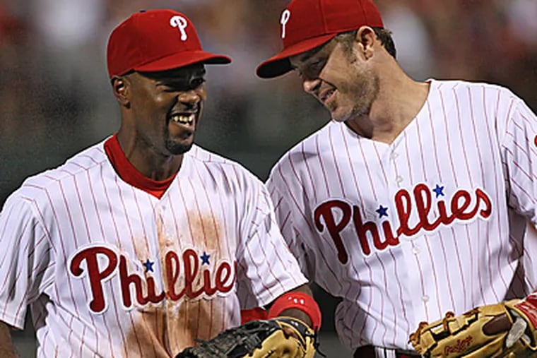 Jimmy Rollins and Chase Utley celebrate turning a double play in the seventh inning.  (David M Warren/Staff Photographer)