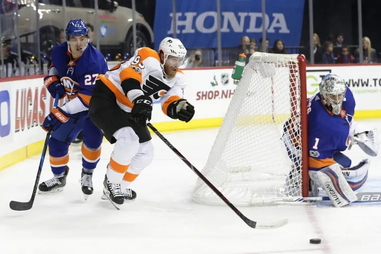 Flyers right wing Jakub Voracek (center) passes away from New York Islanders Anders Lee (left) and goalie Thomas Greiss during the first period of the Flyers 4-3 overtime loss to the Islanders.