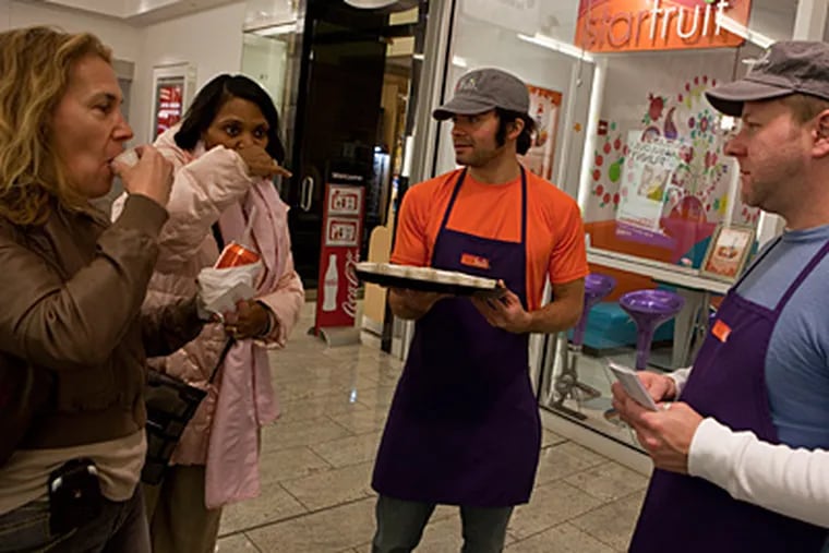 Jeff Paulus, right, manager of Starfruit Cafe, and Huber Trenado serve samples of kefir with fruits, a yogurt drink that is a staple in Eastern Europe, to Malkah Hegel, left, and Joan Obanner at Block 37 Pedway Level in Chicago, Illinois. (Zbigniew Bzdak/ Chicago Tribune/MCT)