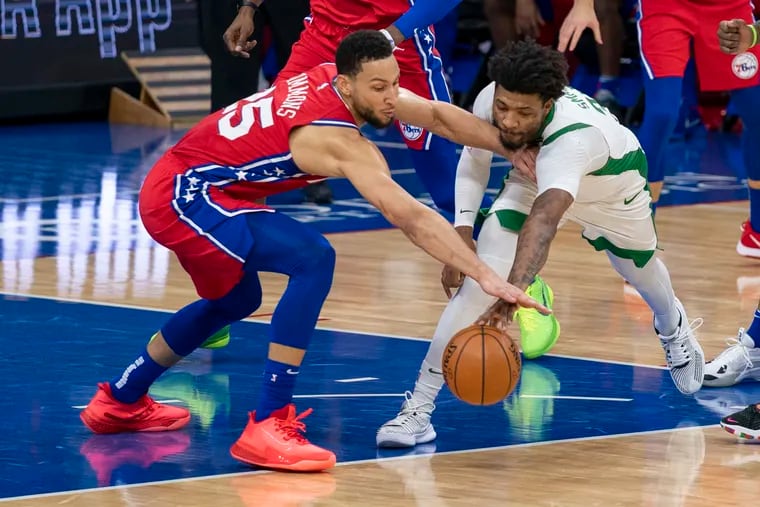 Ben Simmons, left, and Boston's Marcus Smart  battle for a loose ball during Friday's Sixers win.