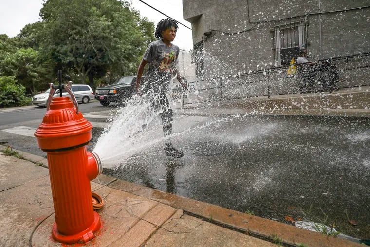 Nayomi Eldemire, 13, runs through an open hydrant off Huntingdon Street in North Philadelphia on Thursday. Expect more of the same Friday.