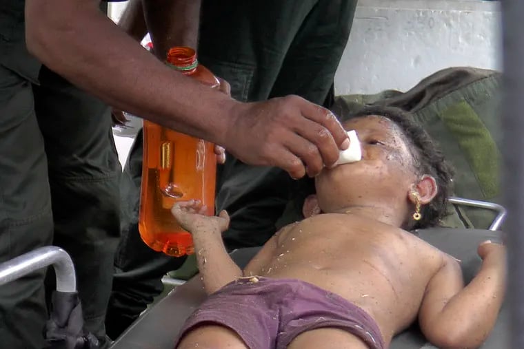 A Sri Lankan soldier cleans the face of a girl after she was found at the site of an explosion and a gun-battle in Kalmunai, eastern Sri Lanka, Saturday, April 27, 2019. Militants linked to Easter suicide bombings opened fire and set off explosives during a raid by Sri Lankan security forces on a house in the country's east.