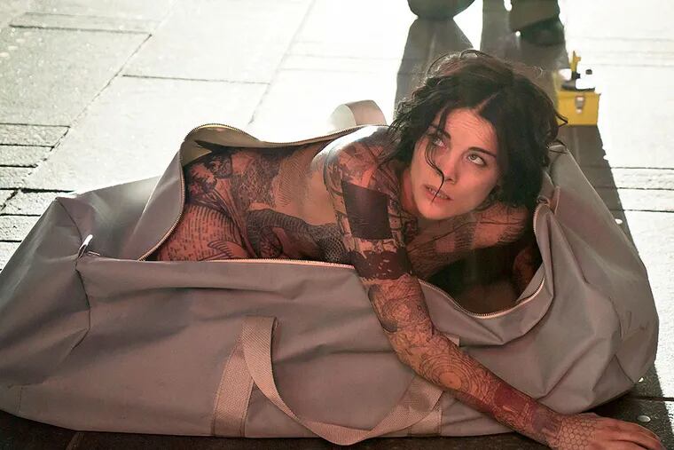 Jaimie Alexander emerges from a duffel bag in the pilot of "Blindspot," covered in tattoos that spark a mystery. VIRGINIA SHERWOOD / NBC