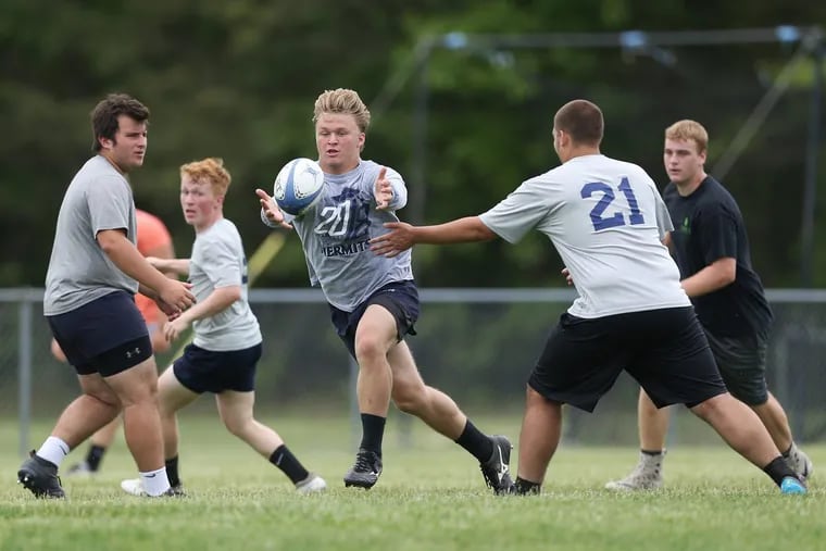 Sean Lenzsch, center, tries to catch the ball during rugby practice at St. Augustine Prep on Wednesday. The team, which will play in the state finals for the fourth year in a row, has begun to attract athletes from other sports.