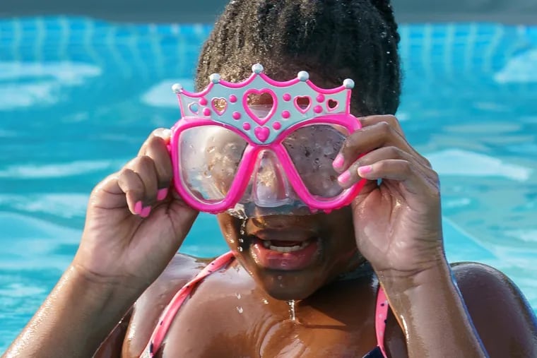 Kayla Melvin, 9 years old, swims in a pool with a swim mask during a hot day in North Philadelphia on July 16, 2019.