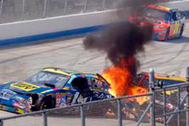Cars driven by Elliott Sadler (left) and Kevin Harvick are aflame after a multicar pileup early on in the Best Buy 400 at Dover International. Driving past the wreck is Jeff Gordon, who finished fifth.