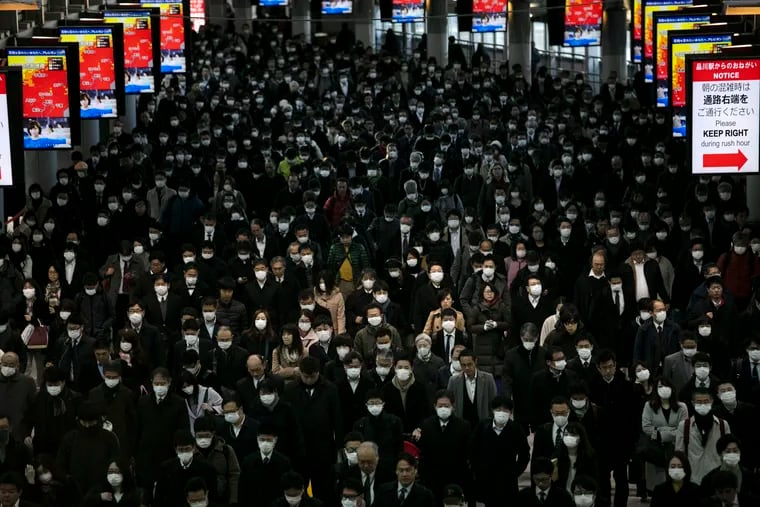 A large crowd wearing masks commutes through Shinagawa Station in Tokyo, Tuesday, March 3, 2020. The Japanese government has indicated it sees the next couple of weeks as crucial to containing the spread of COVID-19, which began in China late last year. (AP Photo/Jae C. Hong)