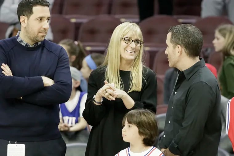 Lara Price (joined by the Eagles' Howie Roseman, right, during a March game at Wells Fargo Center) is third on the masthead with the Sixers. She's the one who deals most with ownership.