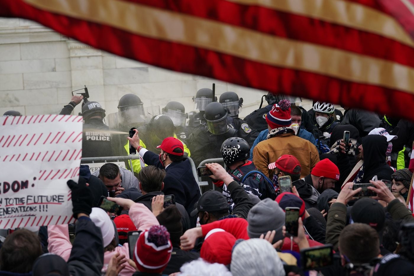 Photo by Jessica Griffin, The Philadelphia Inquirer - A mob engages with police trying to get past the barriers outside the U.S. Capitol building on January 6, 2021.
