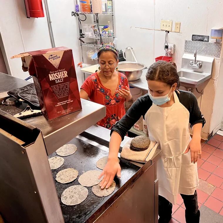Masa Cooperativa member Carmen Guerrero (left), with Maria Roxana Amaya Lemus, making tortillas on the grill in the cooperative's kitchen at 1149 S. Ninth St. on March 19, 2023.