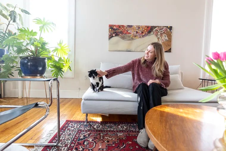 Kate Levy, 27, the renter behind the popular my.philly.home TikTok and Instagram accounts, poses for a portrait with her cat Tetris, 2, in her apartment.