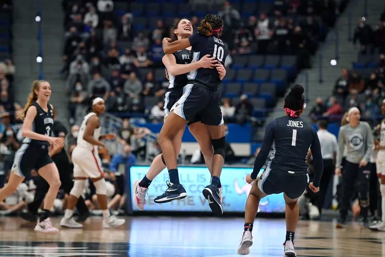 Villanova's Brianna Herlihy and Villanova's Christina Dalce (10) embrace in the air as they celebrate their team's win in an NCAA college basketball game against Connecticut, Wednesday, Feb. 9, 2022, in Hartford, Conn. (AP Photo/Jessica Hill)