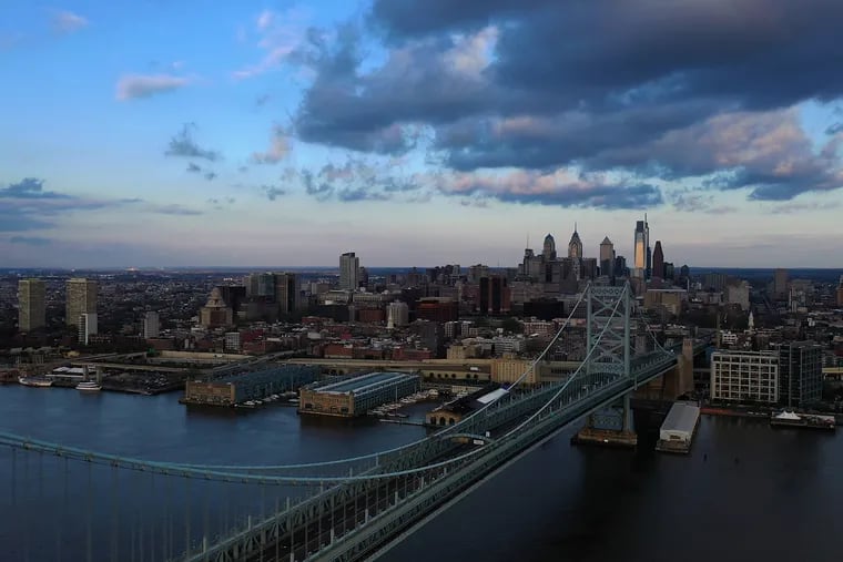 The Benjamin Franklin Bridge and Philadelphia skyline as seen from a drone flying over the Delaware River.