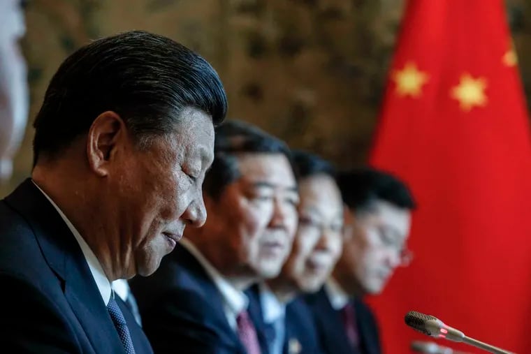 Chinese President Xi Jinping, left, sits in front of the Italian Premier Giuseppe Conte ahead of the signing ceremony of a memorandum of understanding at Rome's Villa Madama, Saturday, March 23, 2019. Italy signed a memorandum of understanding with China on Saturday in support of Beijing's "Belt and Road" initiative, which aims to weave a network of ports, bridges and power plants linking China with Africa, Europe and beyond. (Giuseppe Lami/ANSA Via AP)