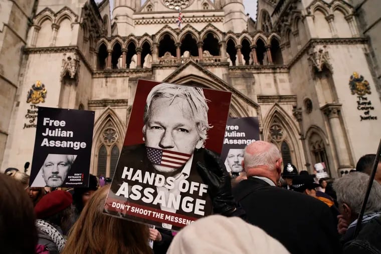 Demonstrators hold placards outside the Royal Courts of Justice in London on March 26, 2024.