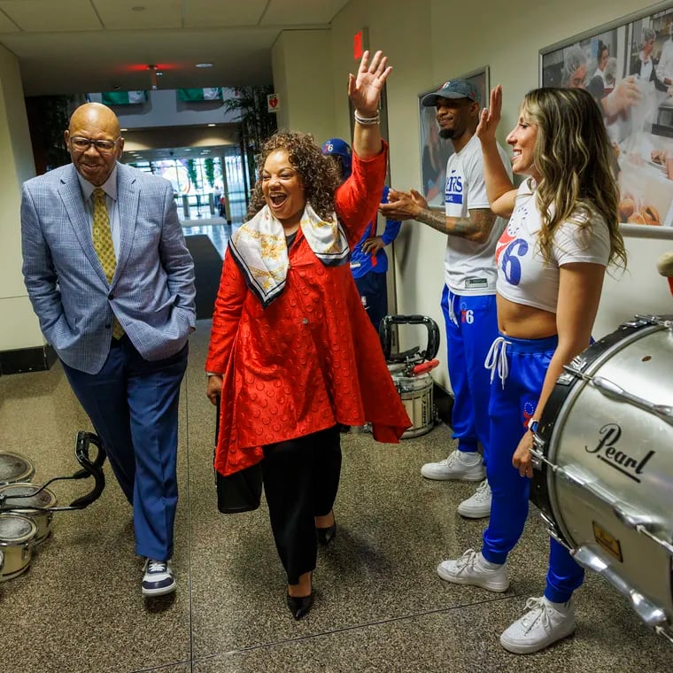 Catherine Hicks (in red), president of the Philadelphia branch of the NAACP, arrives for a news conference with Sam Staten Jr., business manager of Laborers' Local 332. The NAACP announced its support for the Sixers proposed Center City arena.