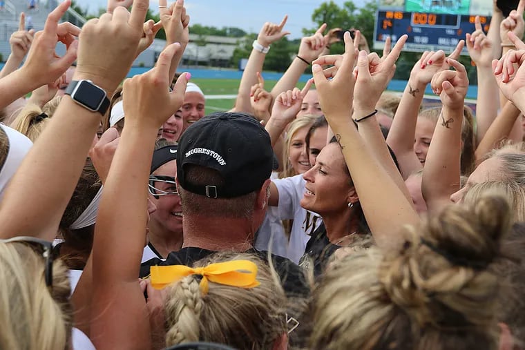 Moorestown coach Deanna Knobloch is surrounded by players after the Quakers won the T of C title in girls' lacrosse in June. It was her final game.