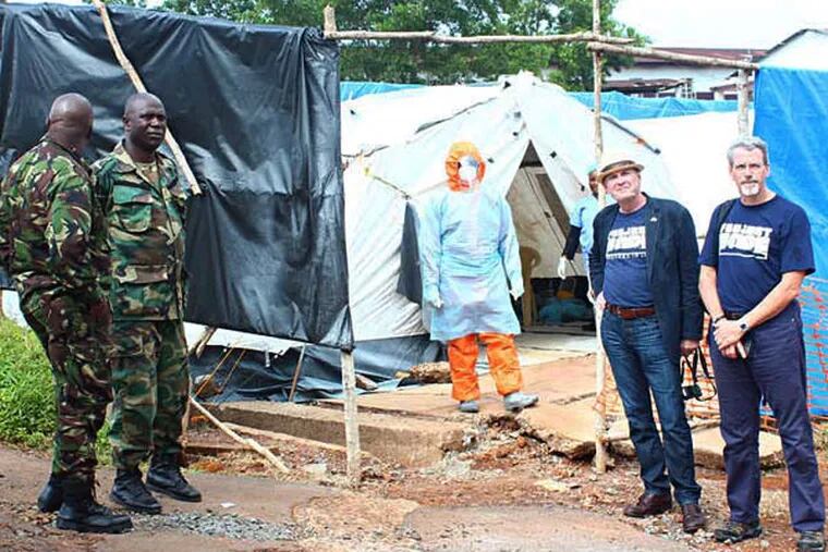 (Photo courtesy of Project HOPE)  Dr. Mel Kohn of Merck (far right, blue shirt, beard) and Frederick Gerber, Project HOPE's director of special programs and operations (blue shirts, white hat), visited Sierra Leone in October 2014 to assess how the nonprofit could aid in the Ebola crisis.