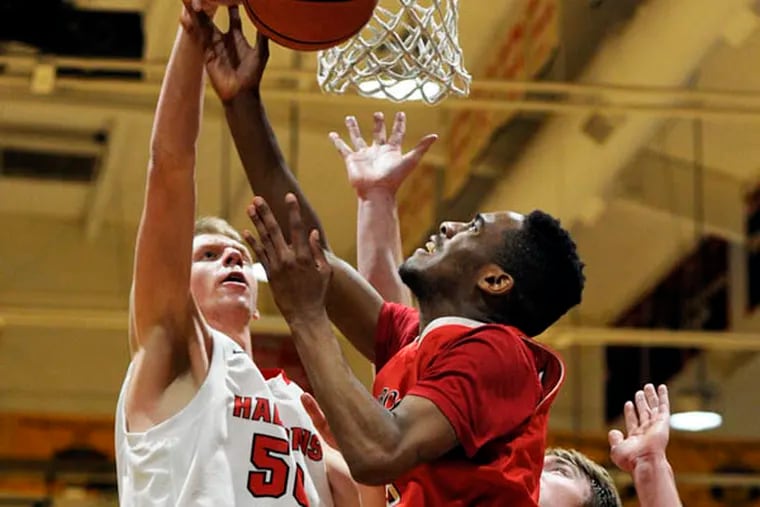 Paulsboro's Tyrique King (center) is blocked by Haddonfield's Luke Leverick (left, #50) as he shoots in the third period of their game at Haddonfield February 19, 2015. ( TOM GRALISH / Staff Photographer )