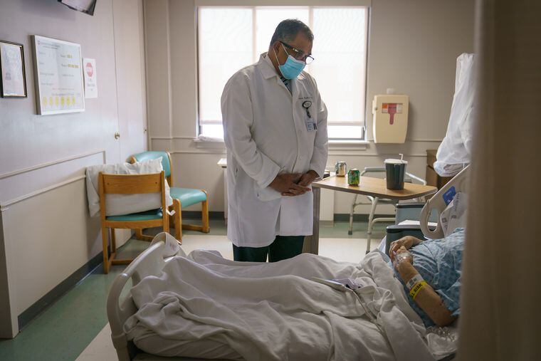 Mathew Mathew, chief medical officer, speaks with a patient at Suburban Community Hospital in Norristown.
