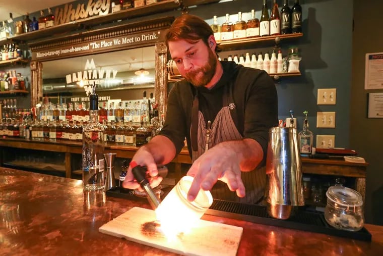 At Manatawny Craft Spirits Shop & Tasting Room, bartender Ben Spirk makes an Italian Market cocktail. Step one: Incinerate a cinnamon stick.