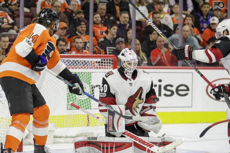 Arizona goalie Scott Wedgewood stops the puck against Flyers center Sean Couturier, who had two goals in Monday’s 4-3 OT loss to the Coyotes.