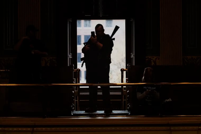 An armed militia member waits inside the Michigan Senate chamber at the Capitol building during the "American Patriot Rally on Capitol Lawn" protest in Lansing, Mich., on April 30.