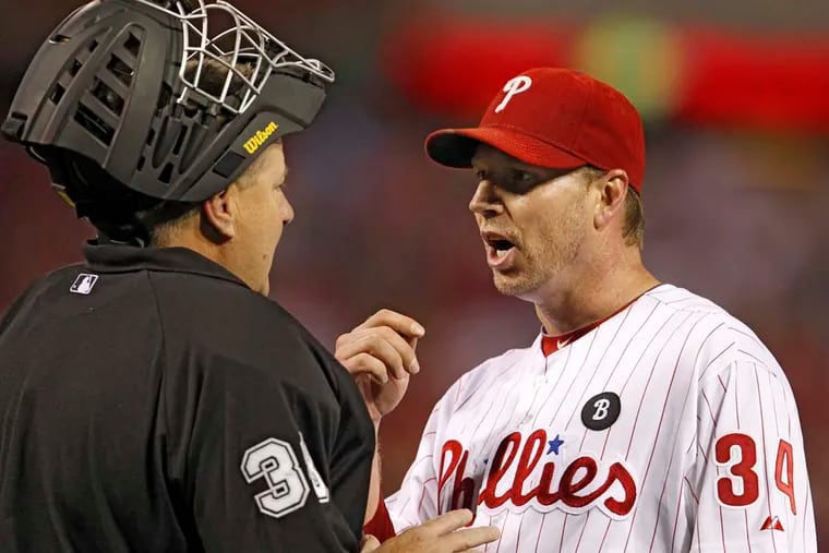 Phillies starter Roy Halladay confers with home plate umpire Gary Cederstrom after the first inning in Game 5 of the 2011 NLDS.  ( Ron Cortes / Staff Photographer )