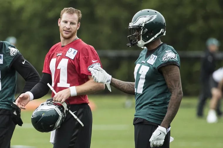 Eagles wide receiver Alshon Jeffery (17) talks things over with quarterback Carson Wentz during OTAs in May.