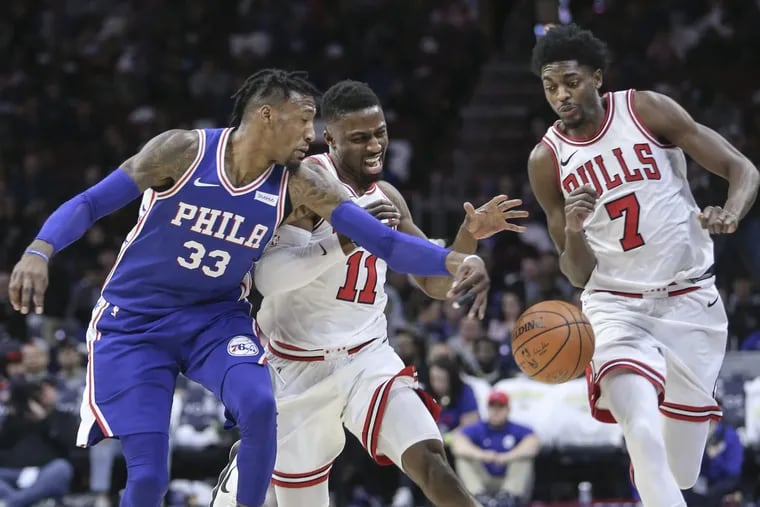 The Sixers' Robert Covington knocking the ball away from the Bulls' David Nwaba (11) and Justin Holiday (7) during the teams’ meeting in January at the Wells Fargo Center.