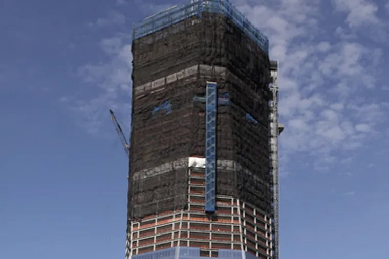 In this April 17, 2012, file photo, One World Trade Center, now up to 100 floors, rises above the Manhattan skyline in New York. On Monday, April 30, One World Trade Center _ being built to replace the twin towers destroyed on 9/11 _ gets steel columns to make its unfinished framework a little higher than the Empire State Building's observation deck, to become the tallest building in New York. (AP Photo/Mark Lennihan)