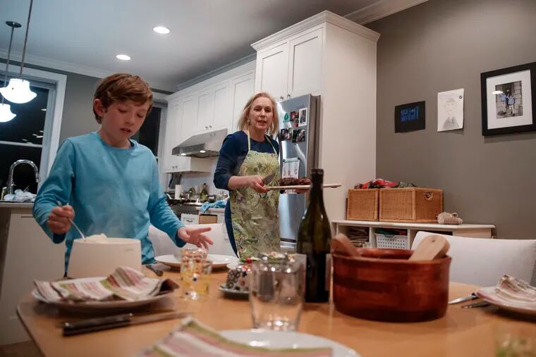 Sen. Kirsten Gillibrand, D-N.Y., and her son Henry Gillibrand set the table for dinner in their home in Washington, Tuesday, Feb. 12, 2019. Gillibrand isn’t just embracing her role as a mother on the campaign trail, she's running on it. She opens her stump speech declaring she will “fight for your children as hard as I would fight for my own.”