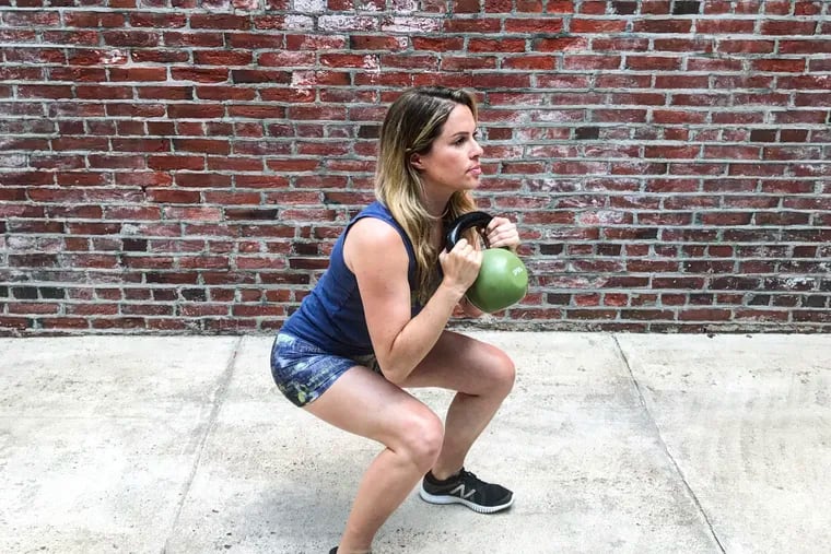 Ashley Blake Greenblatt demonstrates a squat using a kettlebell. A three-piece set is a great pick for the home gym buff on your Christmas shopping list.