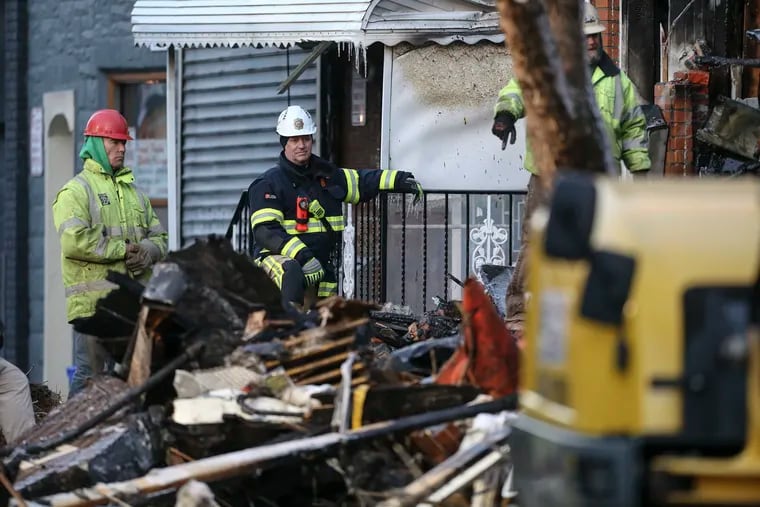A fire marshal watches Friday as firefighters work to recover victims of the explosion and fire on the 1400 block of South Eighth Street.