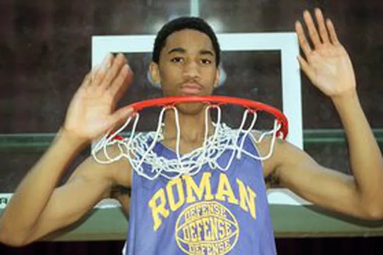 Eddie Griffin poses in the basket at Roman Catholic High School. The Inquirer named him player of the year in 2000. He went on to a checkered five-year career in the NBA.