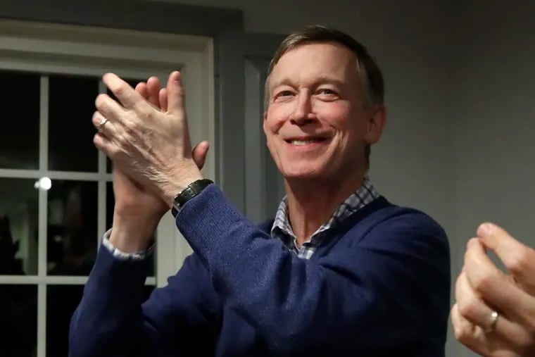 Former Colorado Gov. John Hickenlooper, left, applauds at a campaign house party, in Manchester, N.H. The Main Line native is running for president as a pragmatist. He also is a former brewpub owner and two-term Denver mayor.
