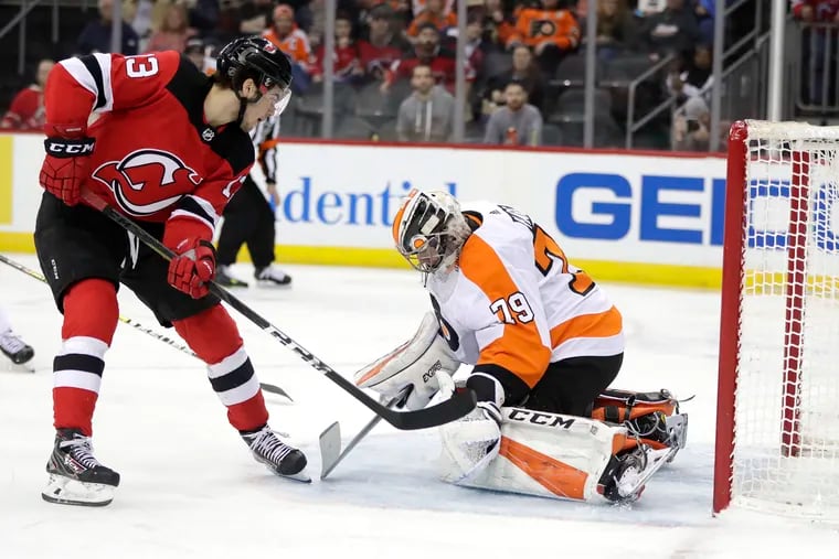 New Jersey Devils center Nico Hischier scores a goal on Philadelphia Flyers goaltender Carter Hart during the second period.