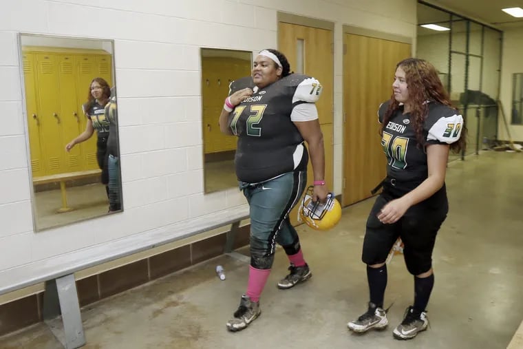 Thomas Edison HS # 72 defensive tackle Barbara Dussinger and # 30 Anaishka Torres walk into the girls locker room to change after Edison's game, at home, against Samuel Fels H.S. on October 12, 2018. Edison won the game 12-6.